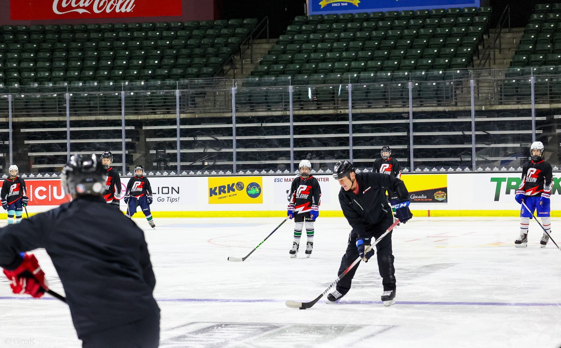 A group of hockey players are practicing on a rink.