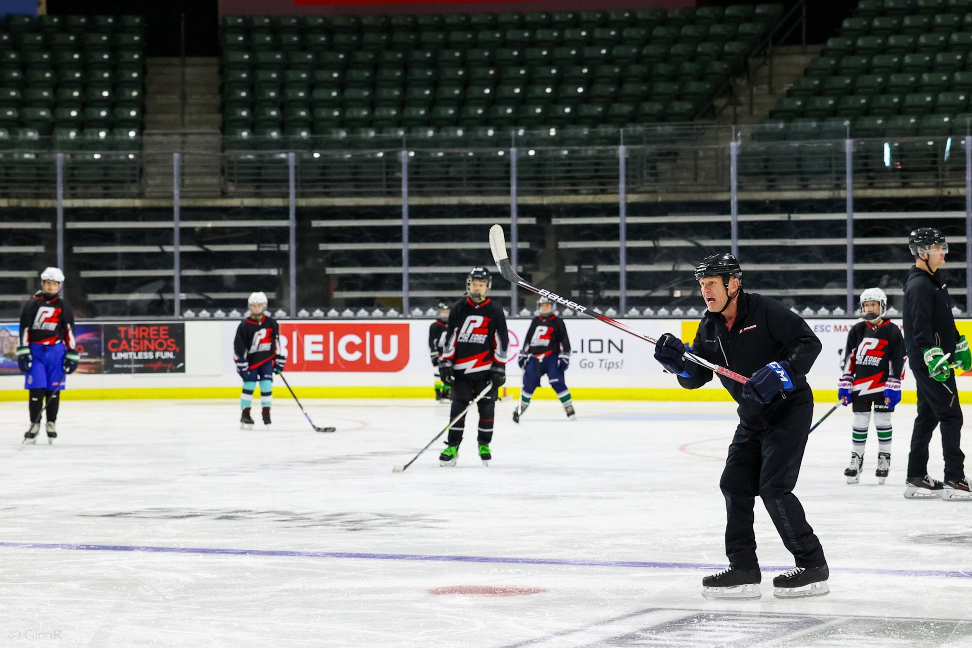 A group of hockey players are practicing on a rink.