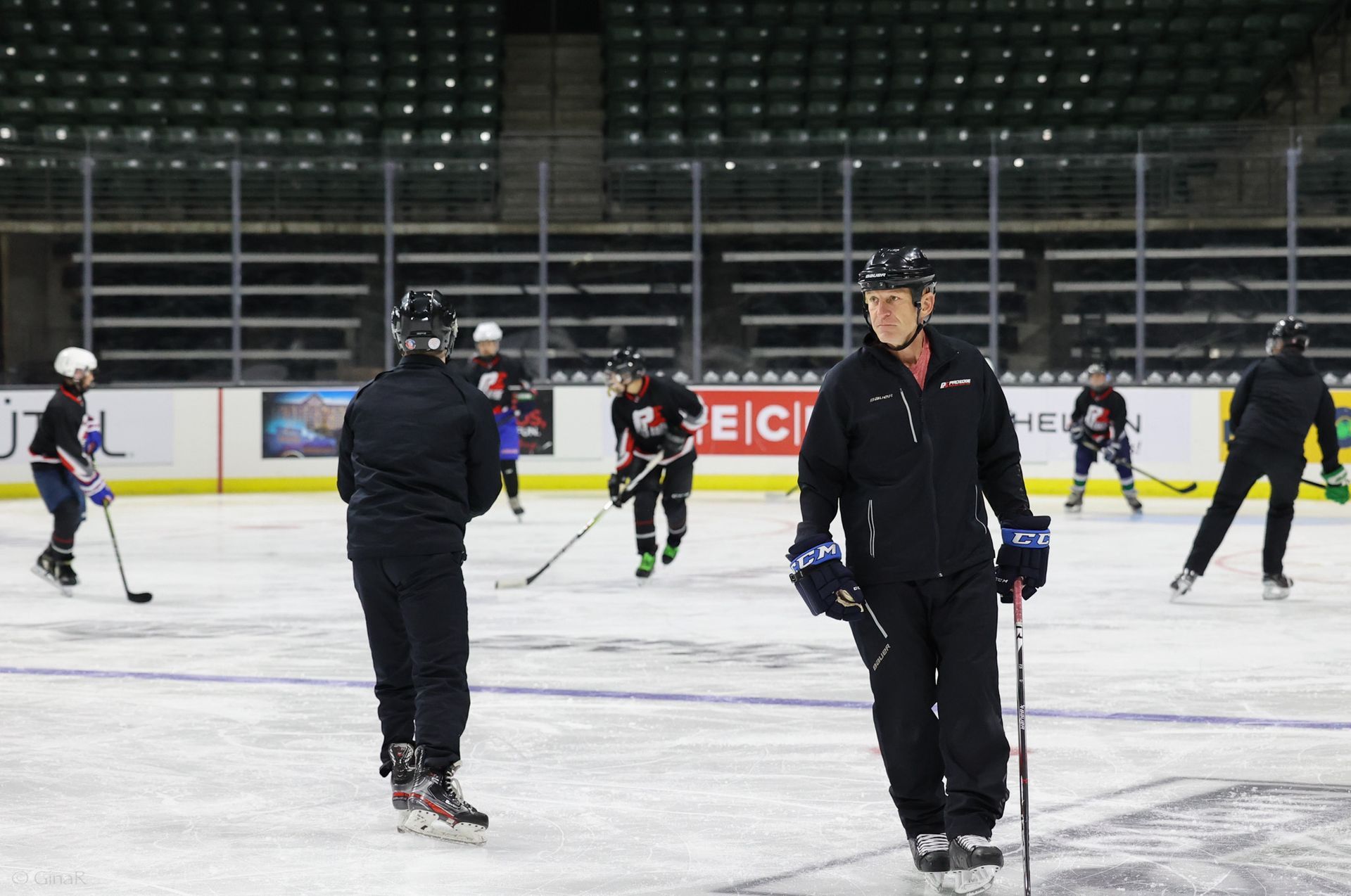 A group of hockey players are practicing on the ice
