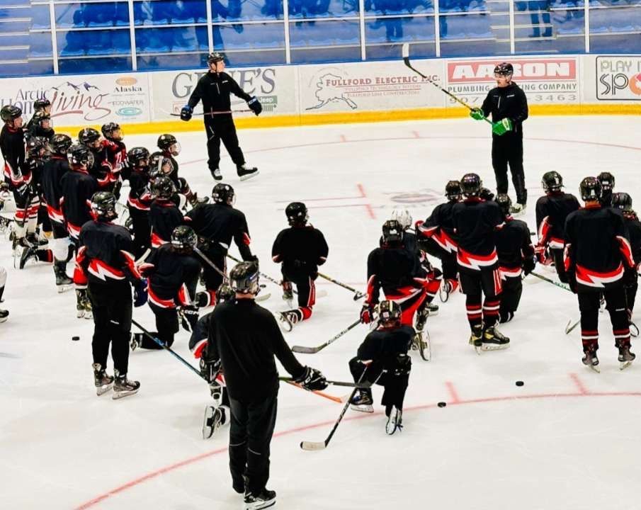 A group of hockey players are practicing on the ice