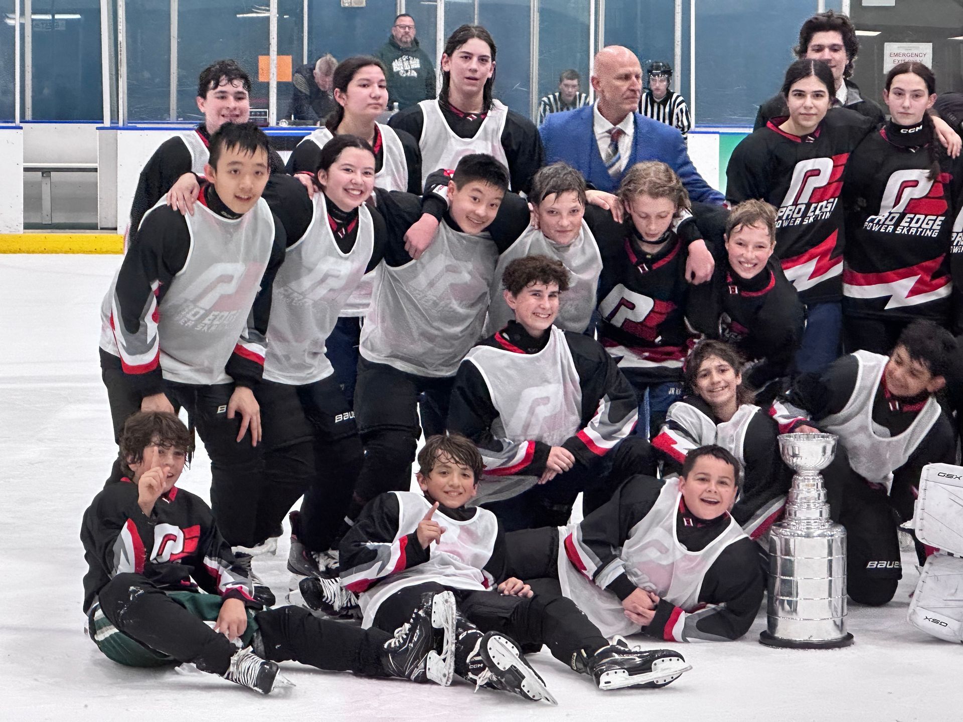 A group of hockey players are posing for a picture on the ice