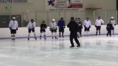 A group of hockey players are standing on the ice in front of a sign that says junior hockey