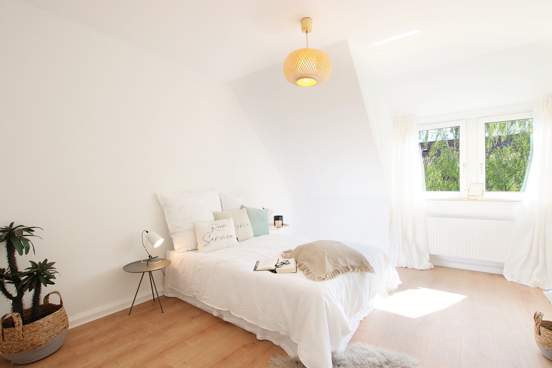 Ein Schlafzimmer mit Bett, Tisch und Fenster.