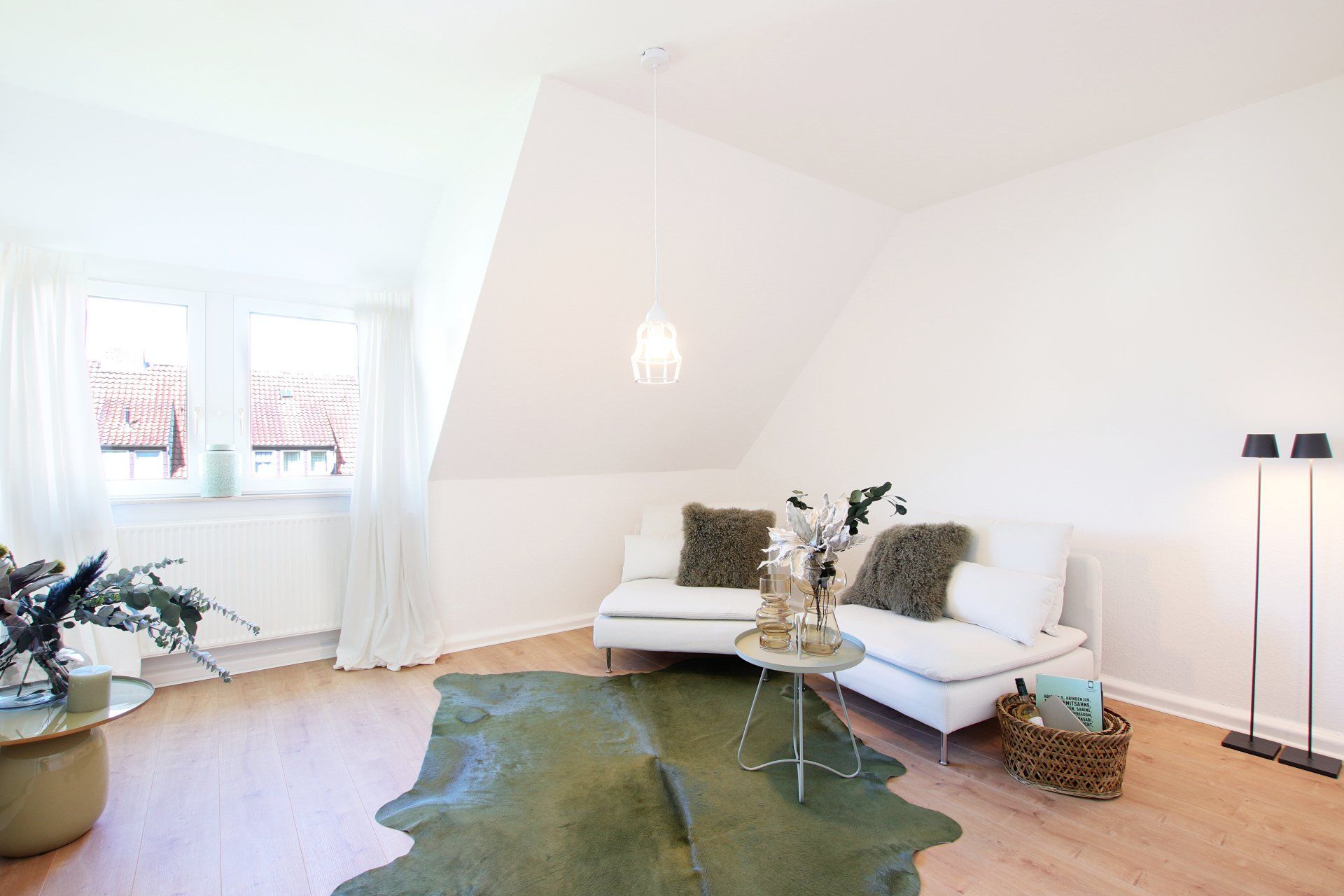 Ein Wohnzimmer mit einem weißen Sofa und einem grünen Teppich.