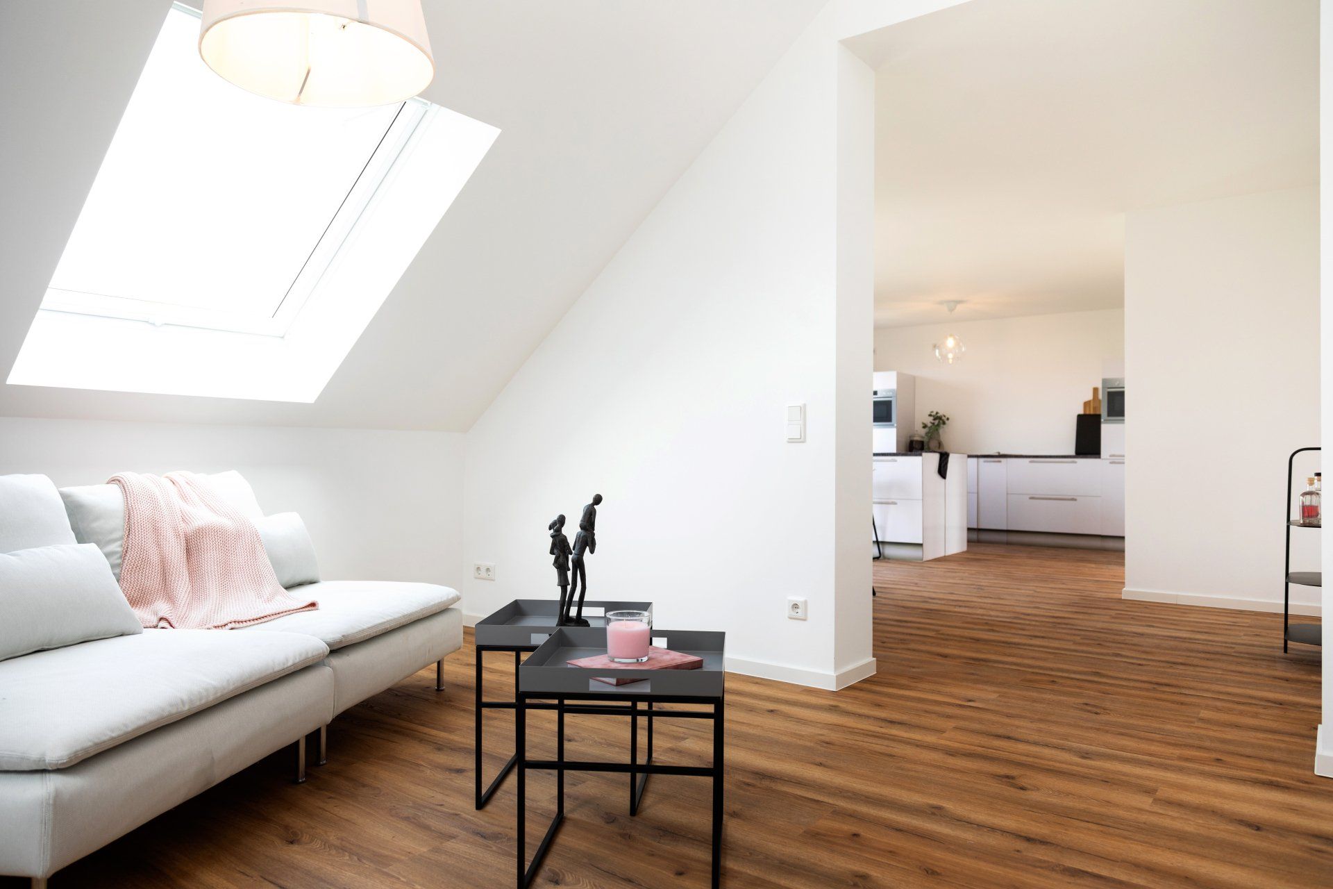 Ein Wohnzimmer mit Couch, Tisch und Dachfenster.