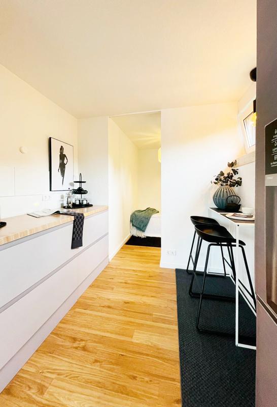 Eine Küche mit weißen Schränken und Holzböden