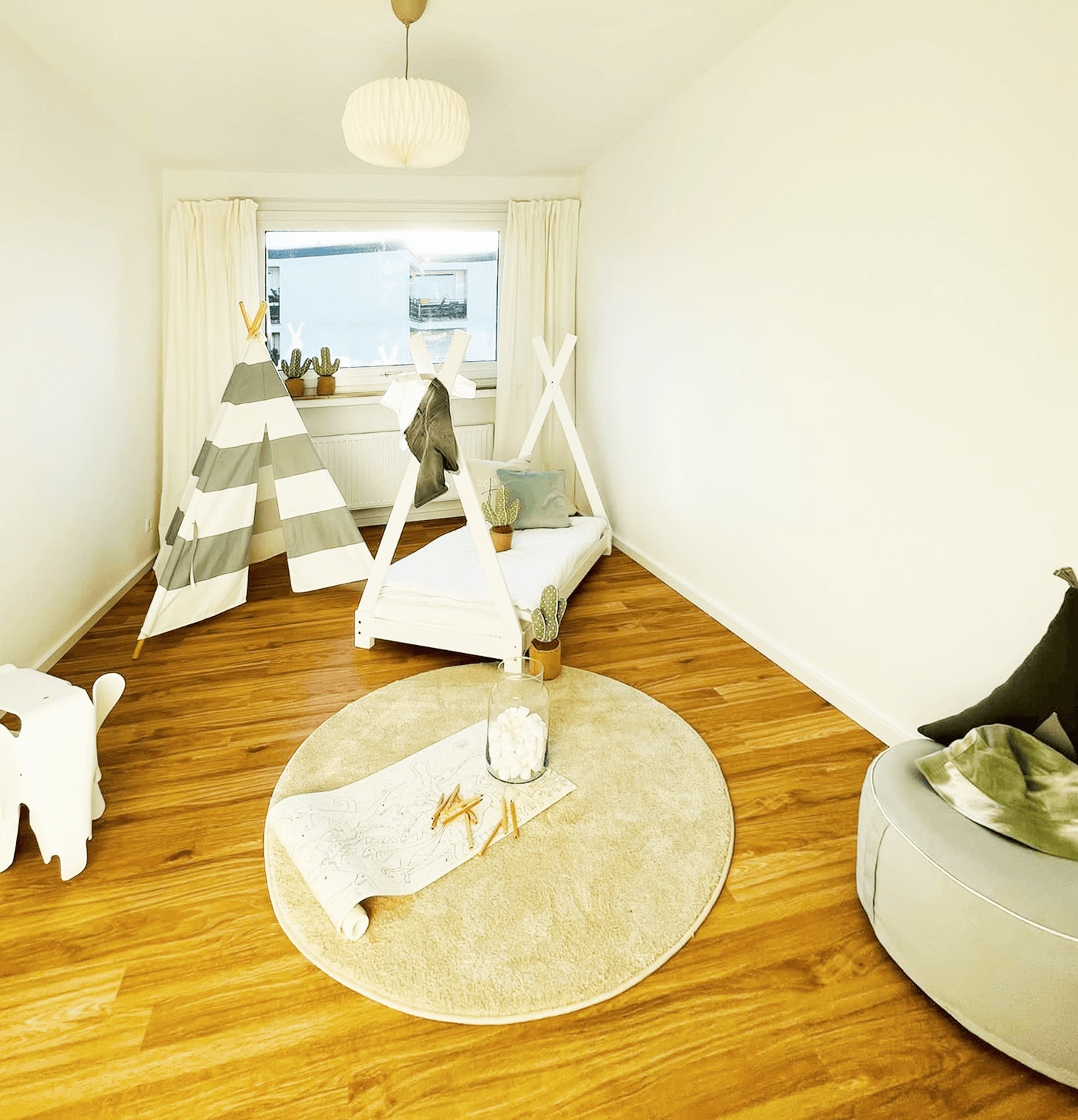 Ein Kinderzimmer mit einem Tipi und einem Stuhl