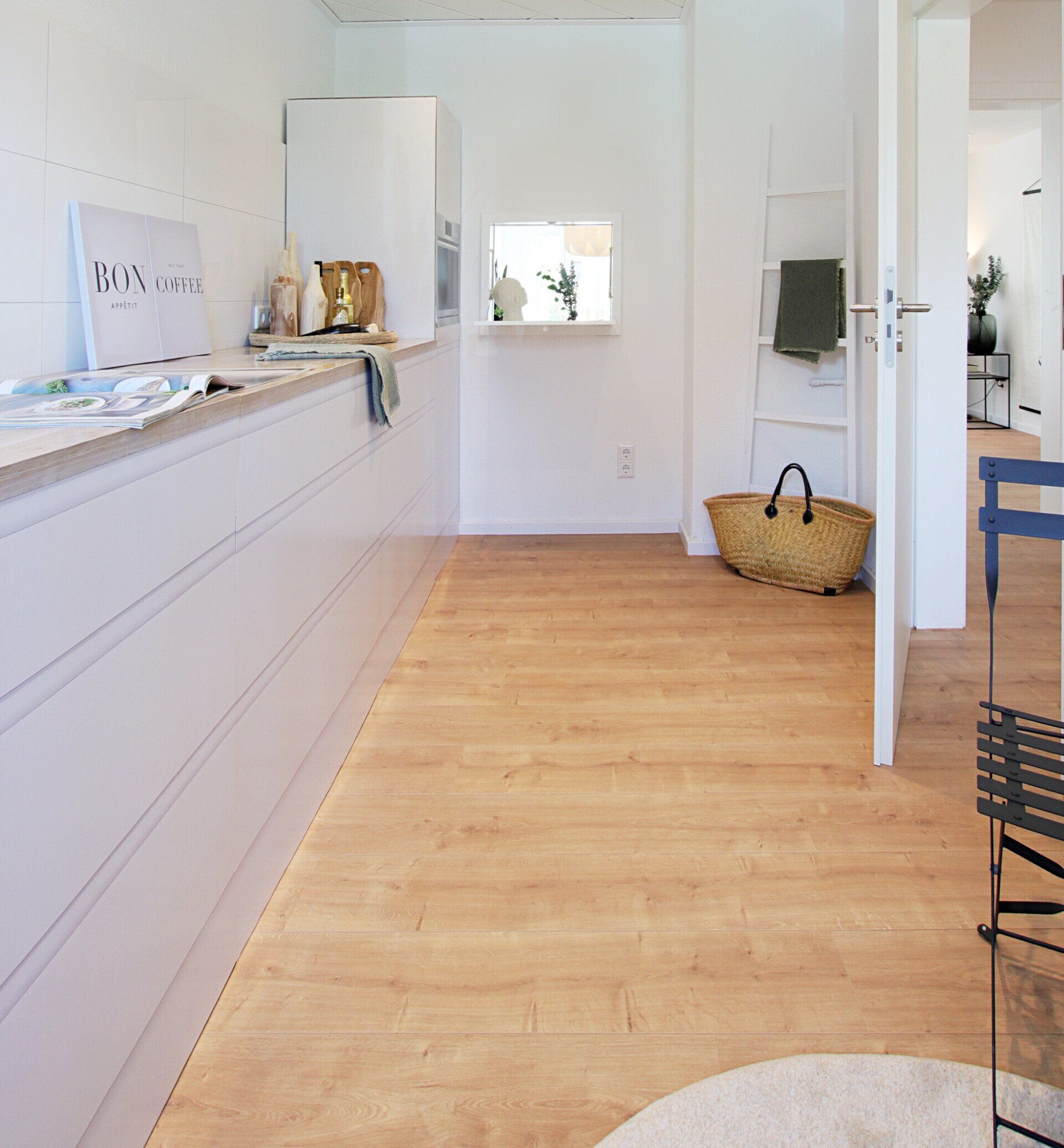 Ein langer Flur mit Holzböden und weißen Wänden