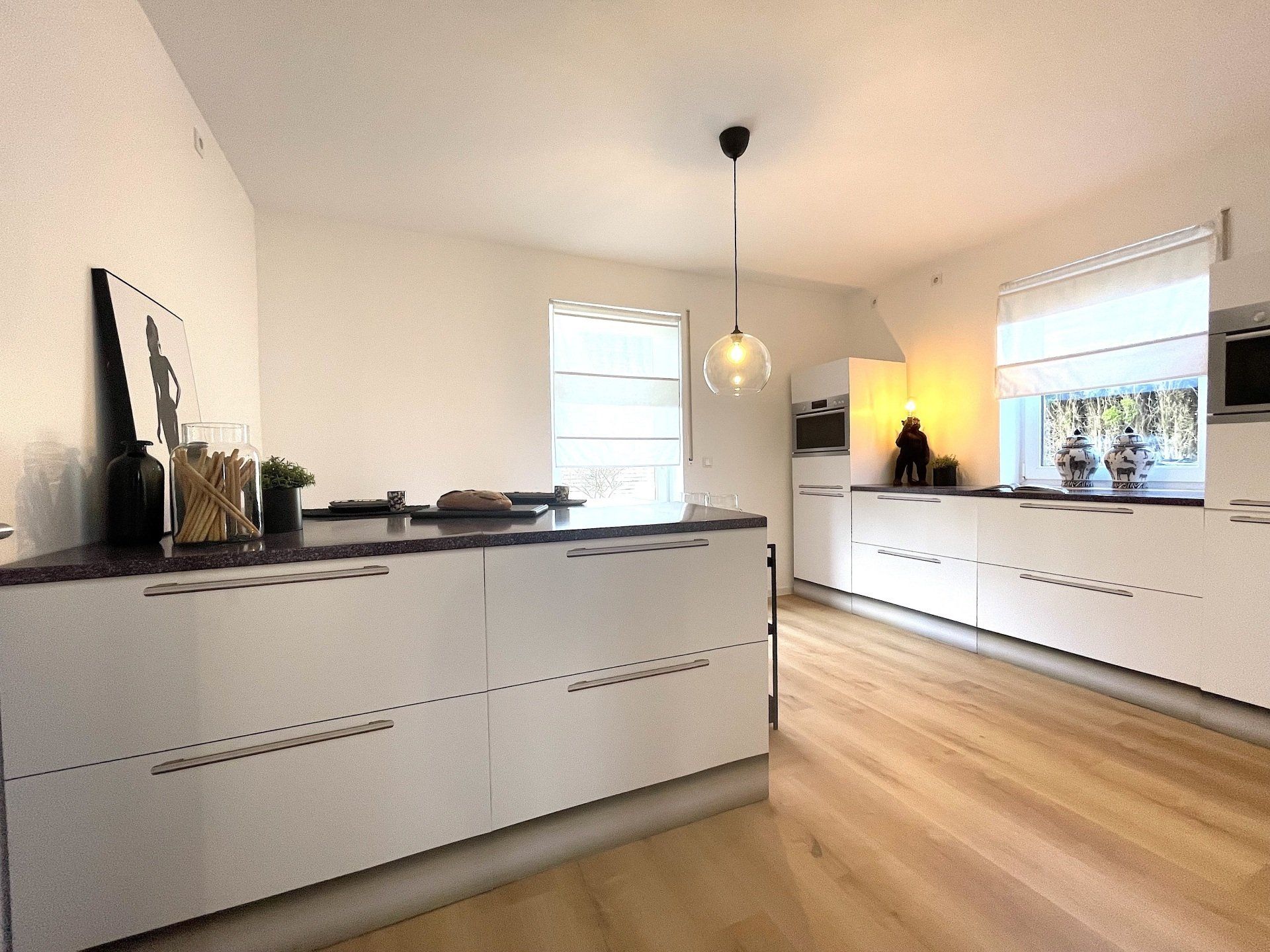 Eine Küche mit weißen Schränken und Holzböden