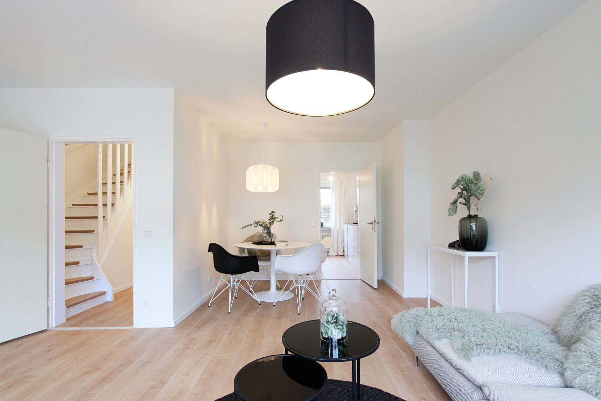 Ein Wohnzimmer mit Couch, Tisch, Stühlen und Treppe.