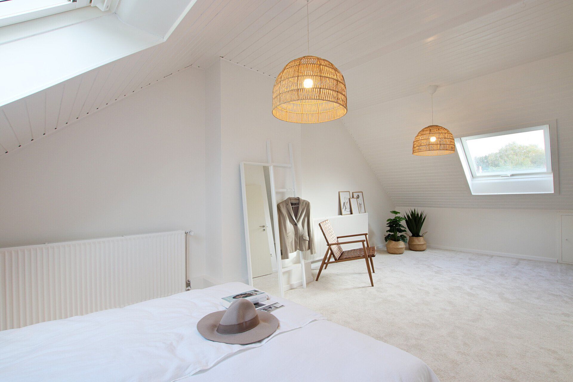 Ein Schlafzimmer mit Bett, Stuhl, Spiegel und Lampen.