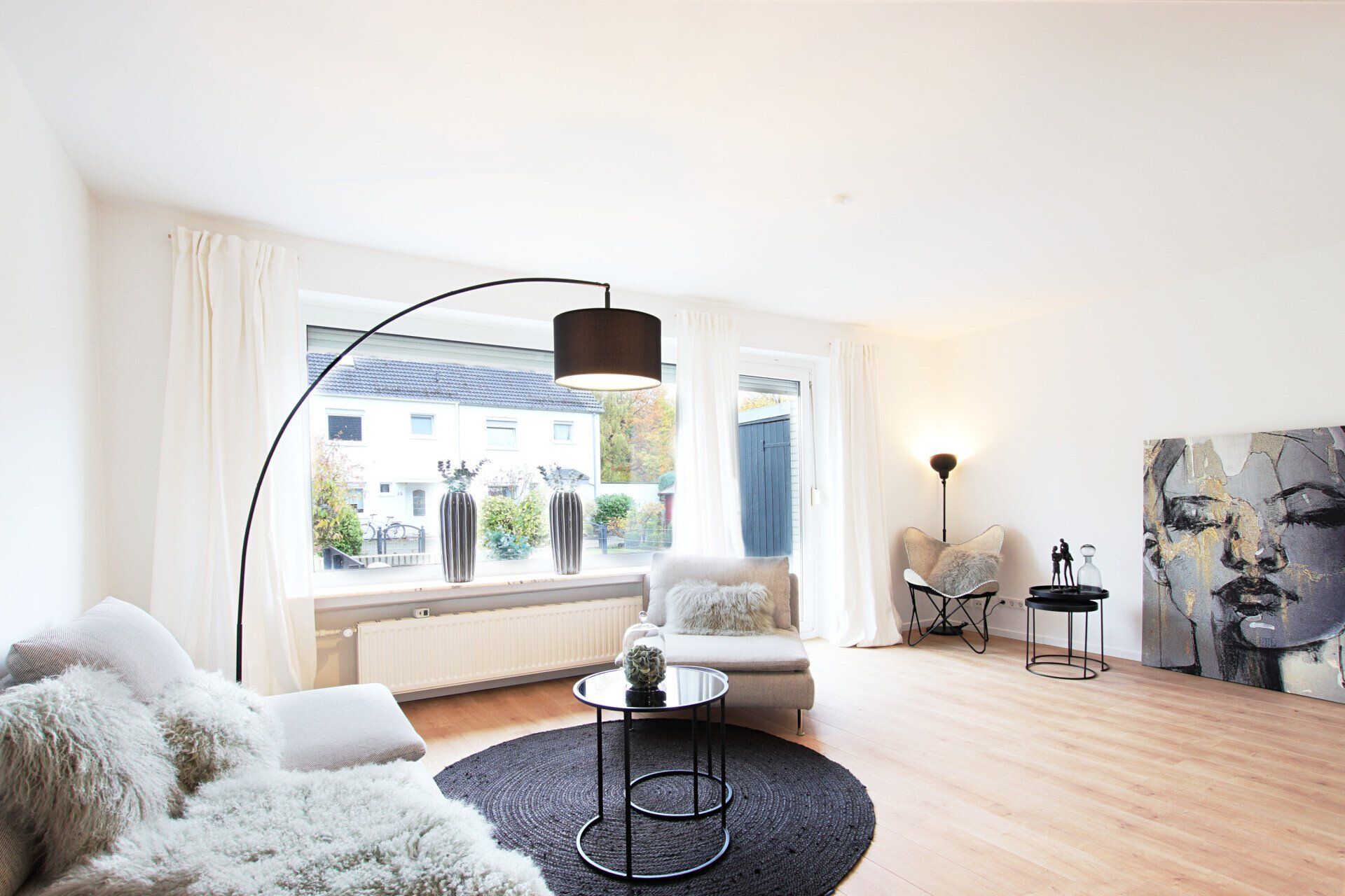 Ein Wohnzimmer mit Couch, Sessel, Tisch und Lampe.