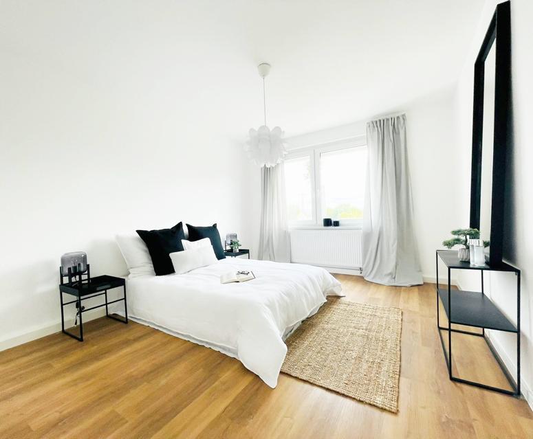 Ein Schlafzimmer mit einem Bett und einem Spiegel an der Wand.