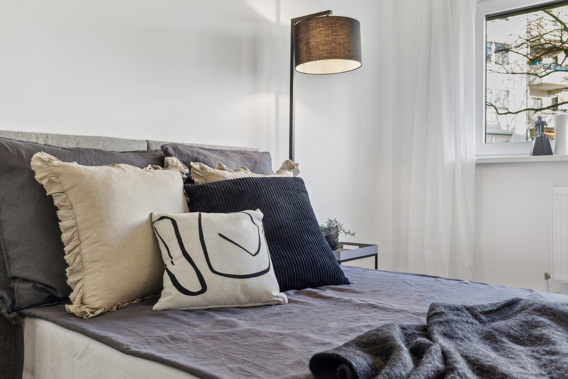 Ein Bett mit einer Lampe und Kissen darauf in einem Schlafzimmer.