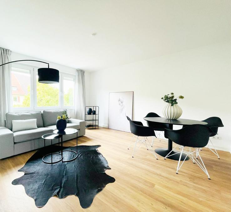 Ein Wohnzimmer mit Couch, Tisch und Stühlen