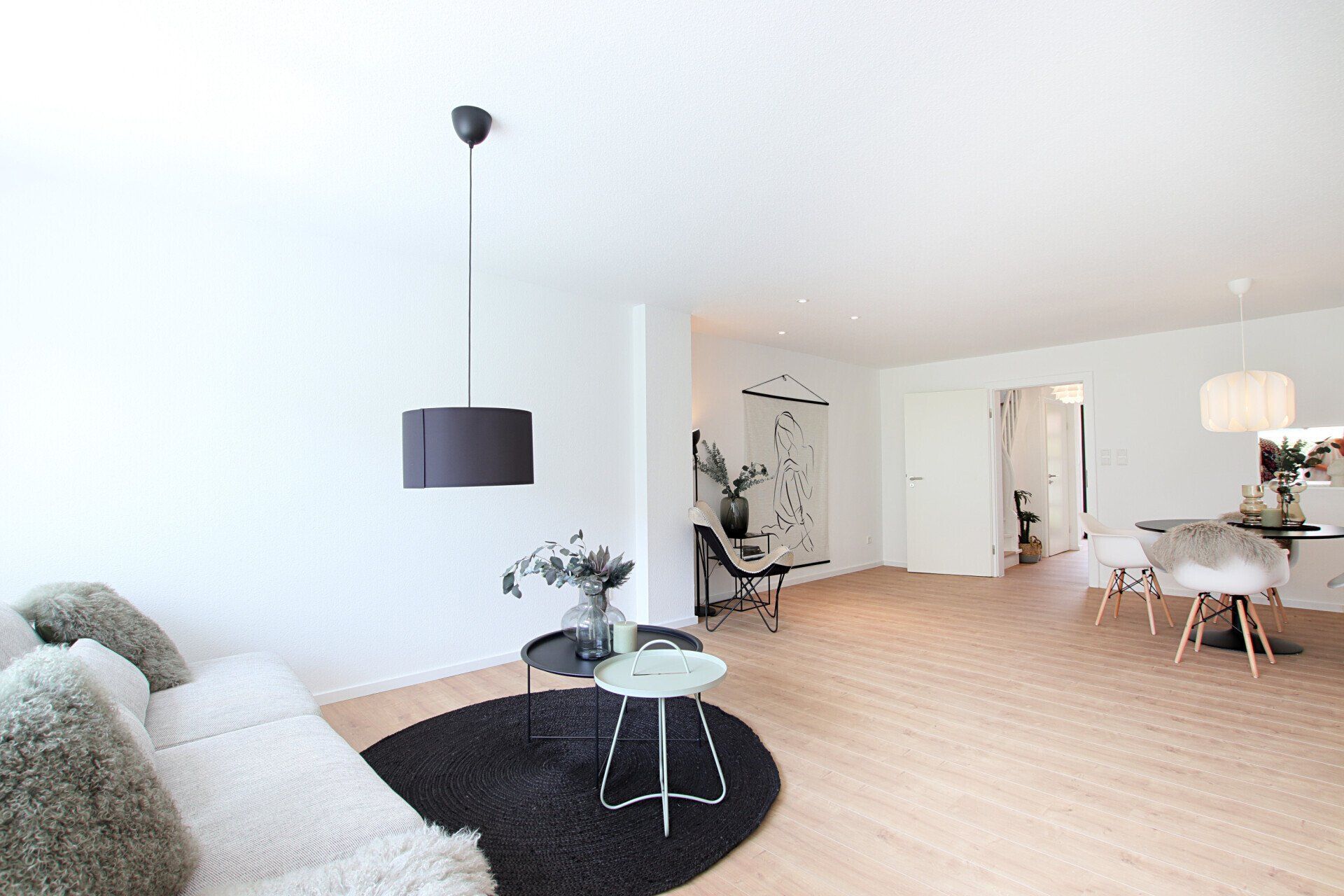 Ein Wohnzimmer mit Sofa, Tisch, Stuhl und Teppich.