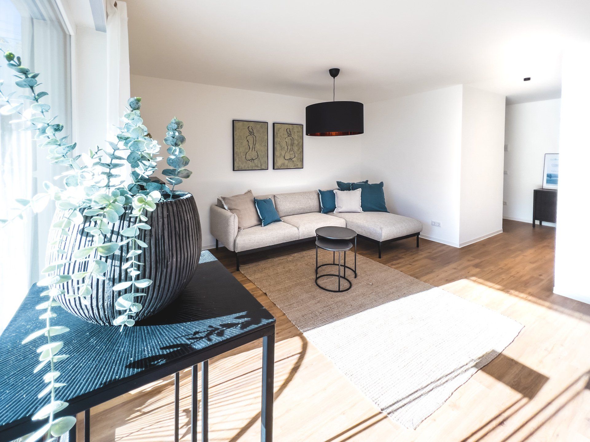 Ein Wohnzimmer mit Sofa, Tisch und Topfpflanze.