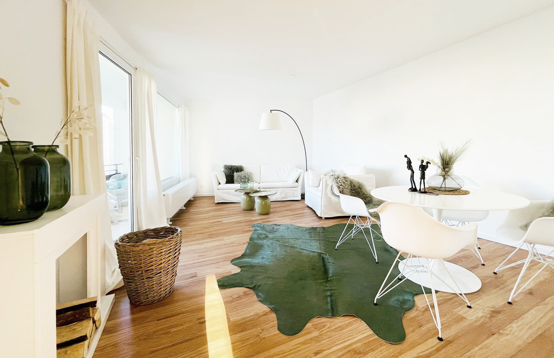 Ein Wohnzimmer mit einem grünen Kuhfellteppich auf dem Boden