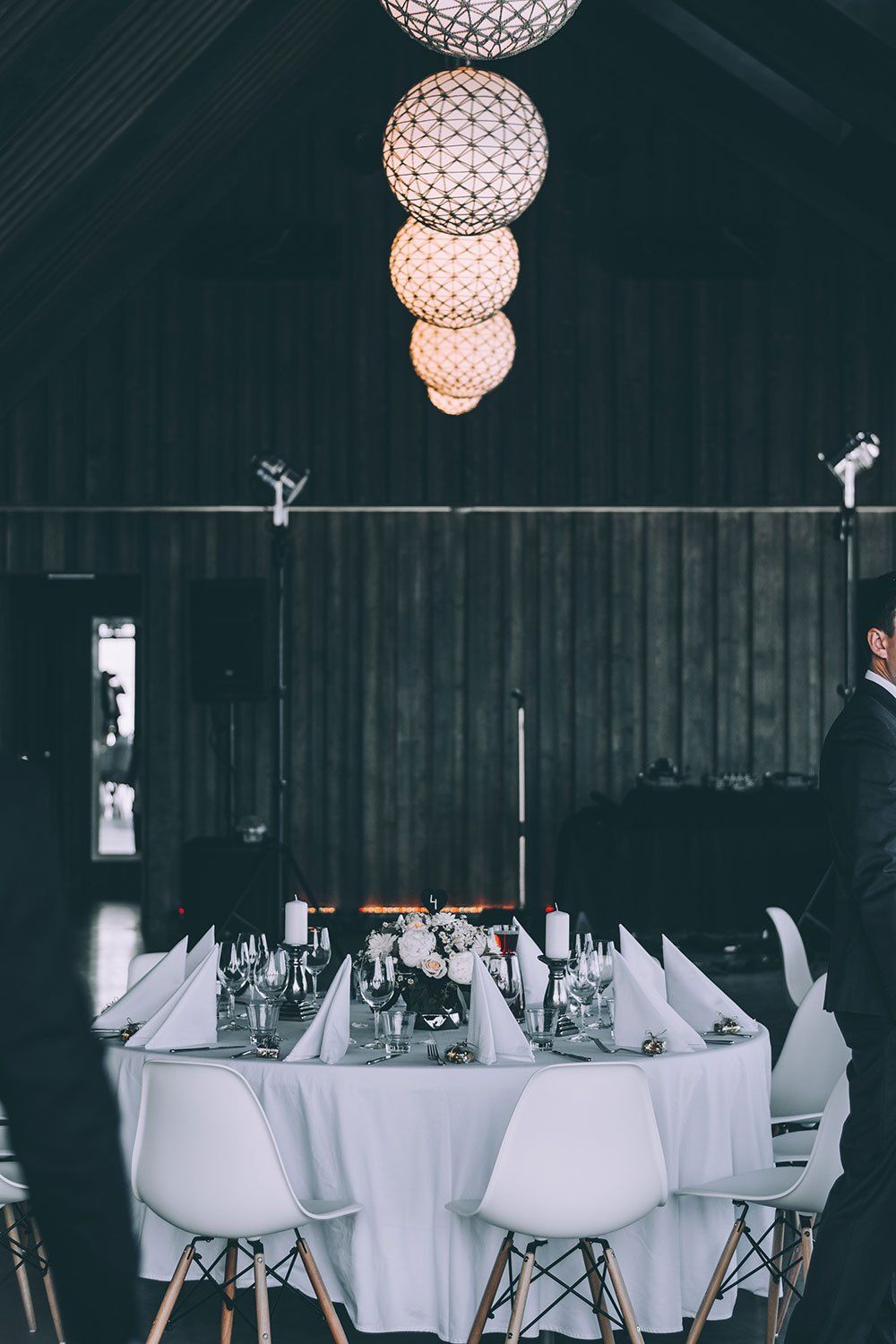 A man is standing in front of a table set for a wedding reception.