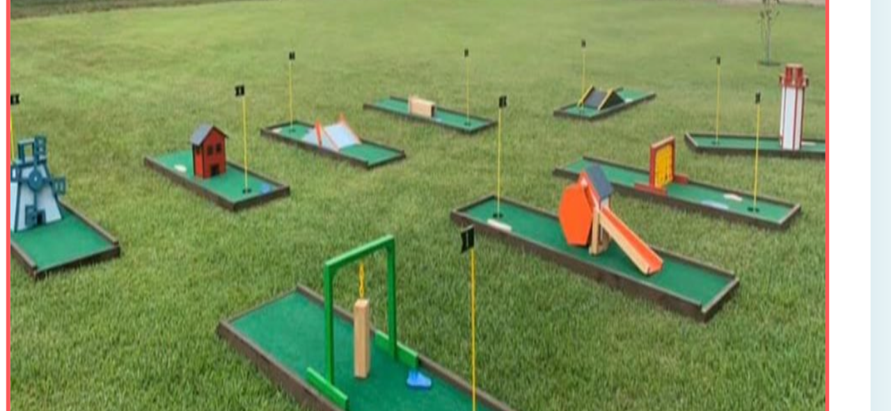A bunch of mini golf courses are sitting on top of a lush green field.