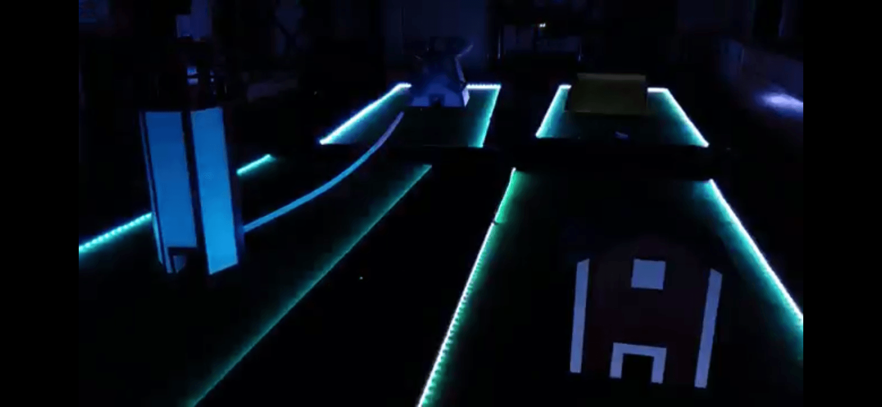 A glow in the dark bowling alley with the letter h on it