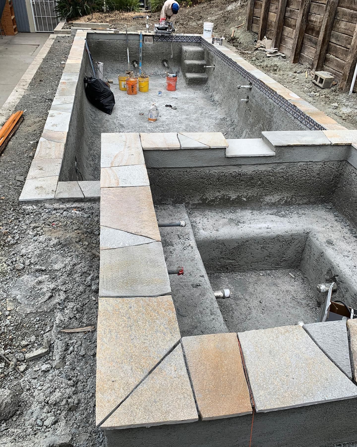A man is working on a swimming pool under construction.