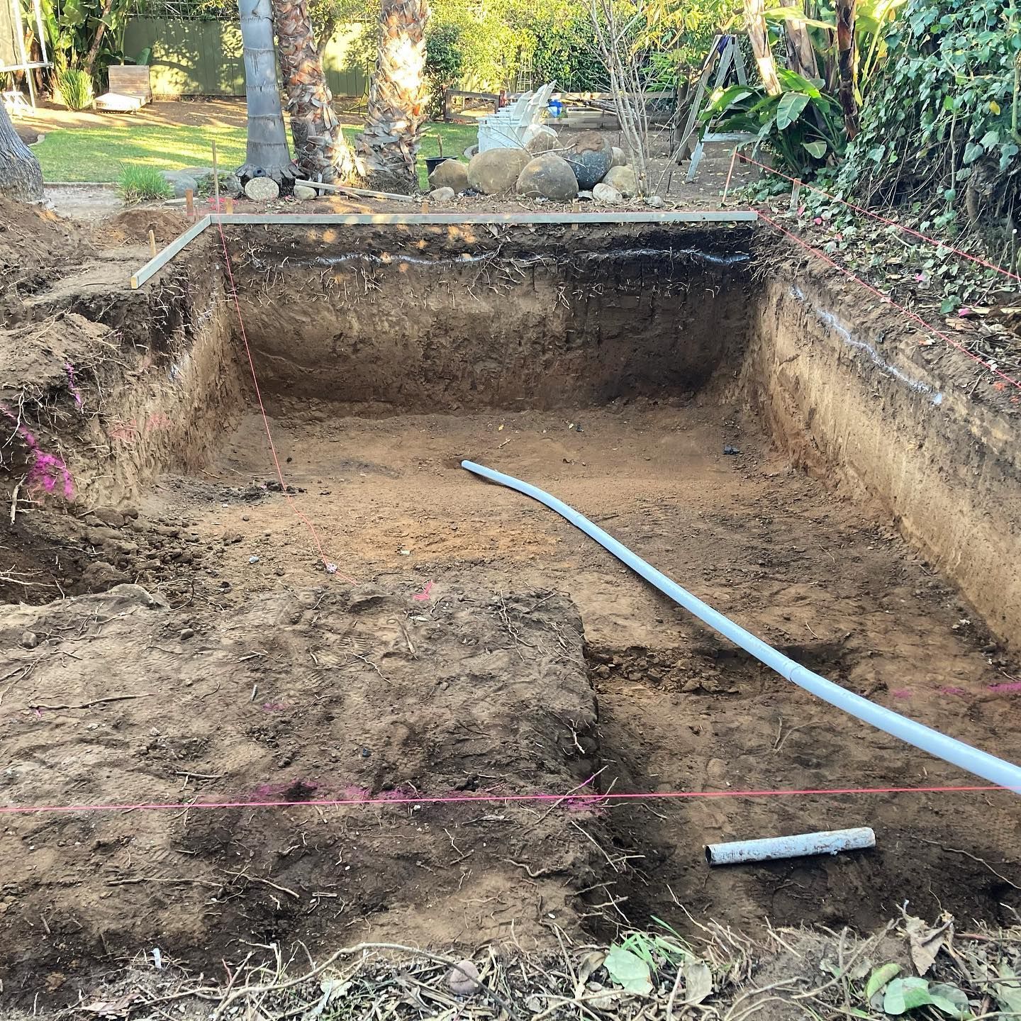 A large hole in the ground with a hose in it.