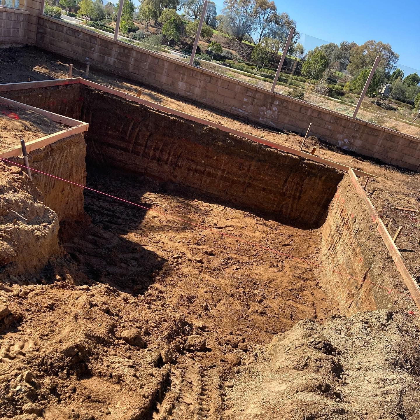 A large hole in the ground is being filled with dirt.