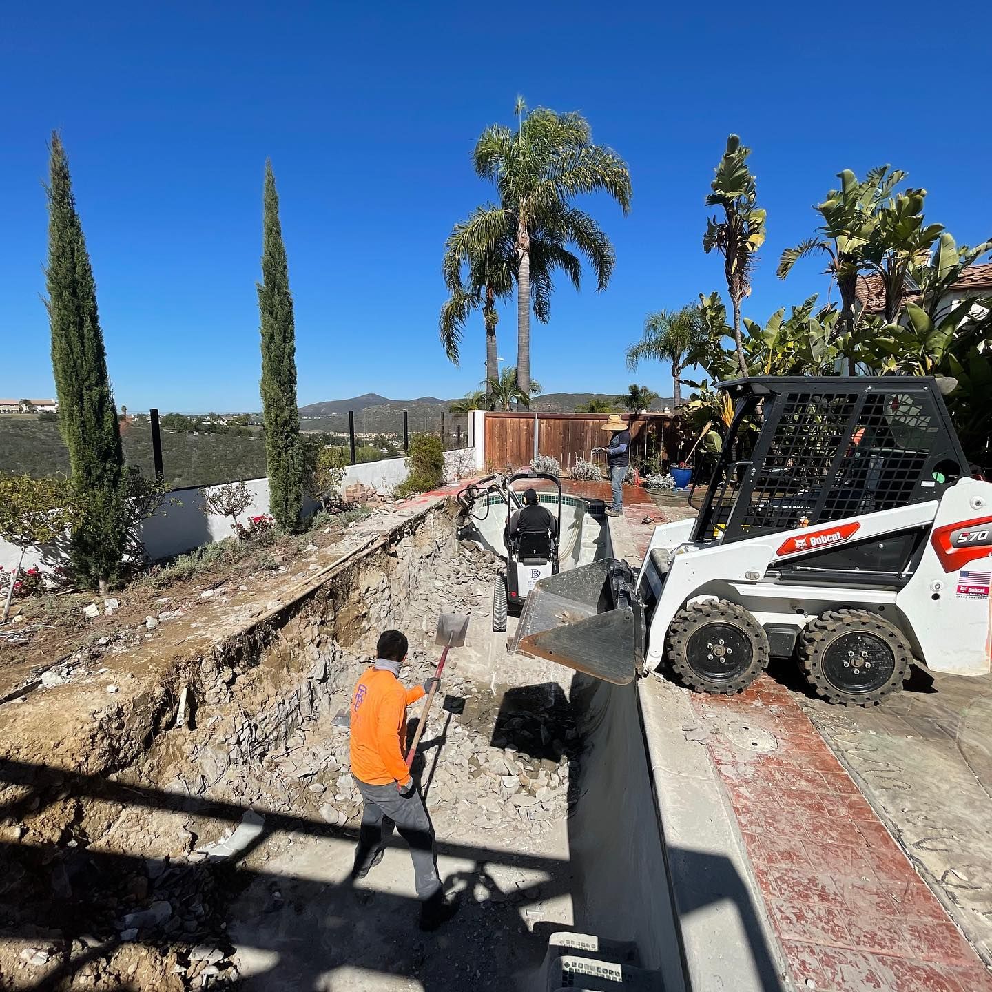 A man is standing in front of a bulldozer that says bobcat on it