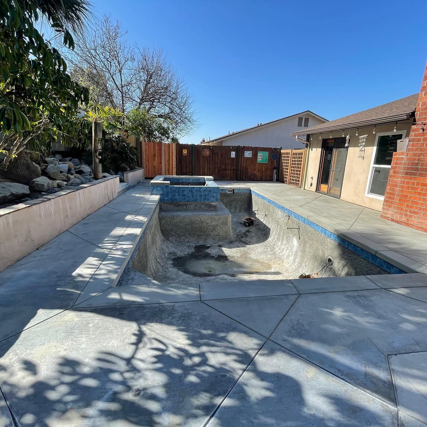 A swimming pool is being built in the backyard of a house.