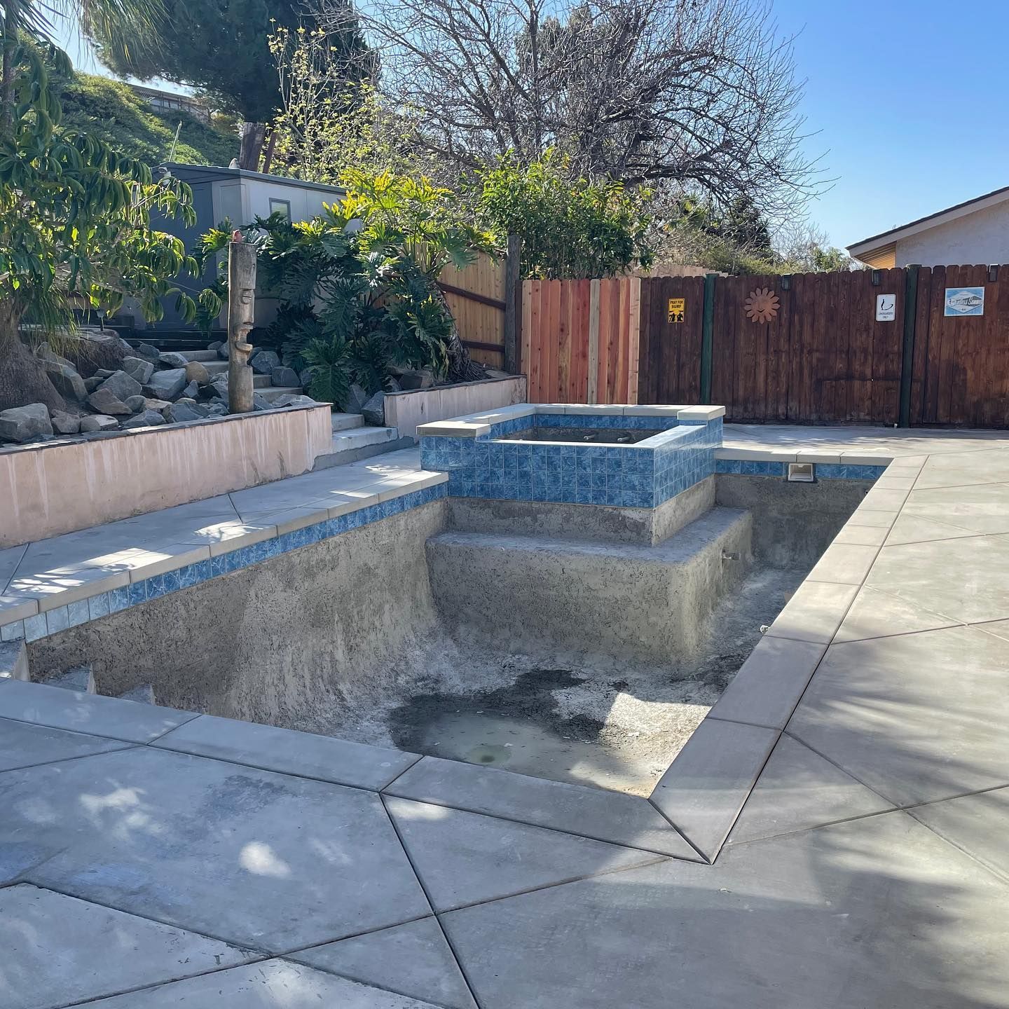 A swimming pool with a wooden fence surrounding it
