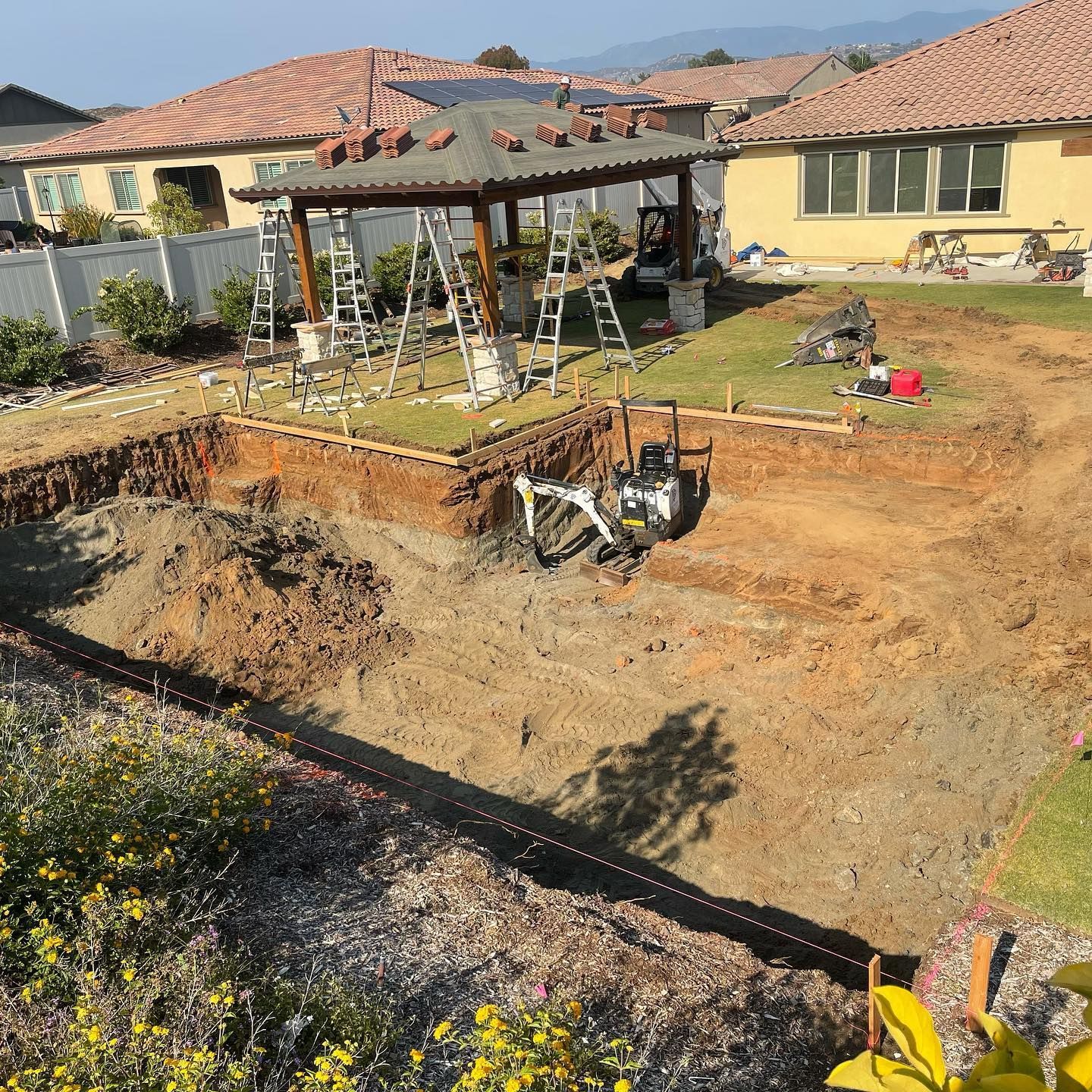 A construction site with a house in the background