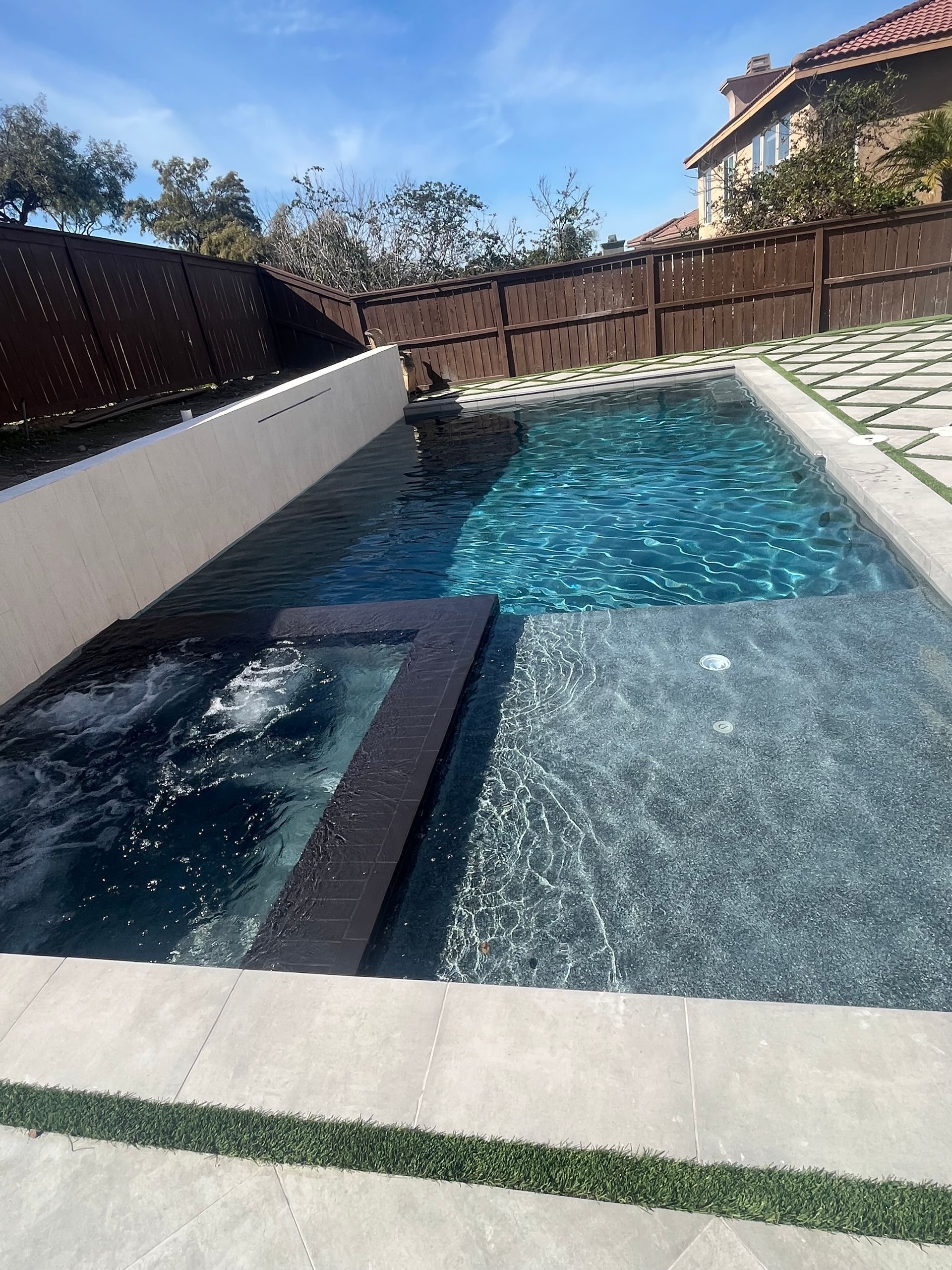 A large swimming pool with a jacuzzi in the middle of it