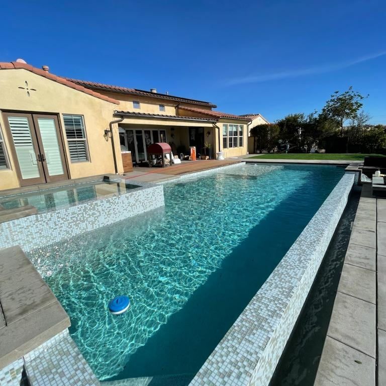 A house with a large swimming pool in front of it