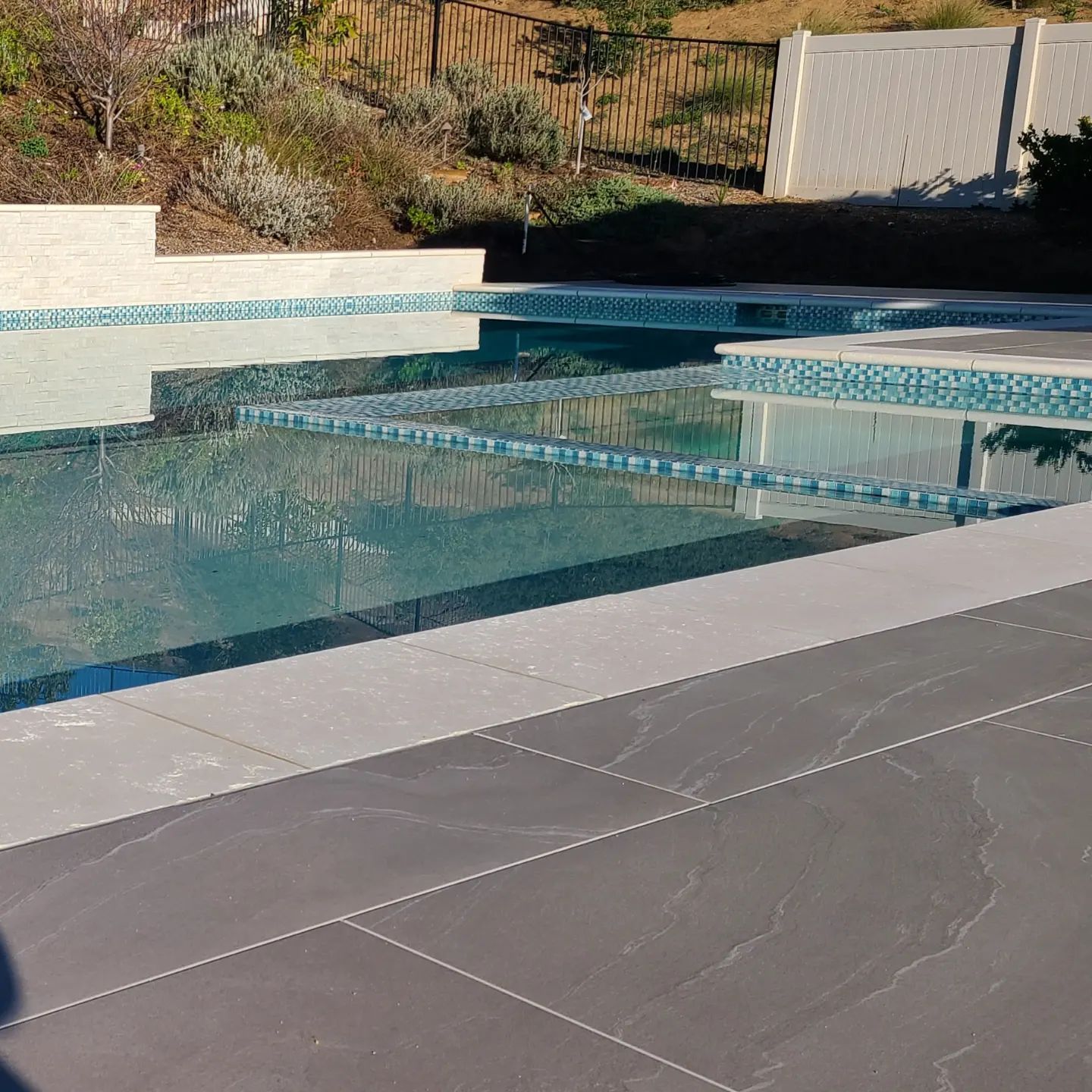 A large swimming pool with a fence in the background