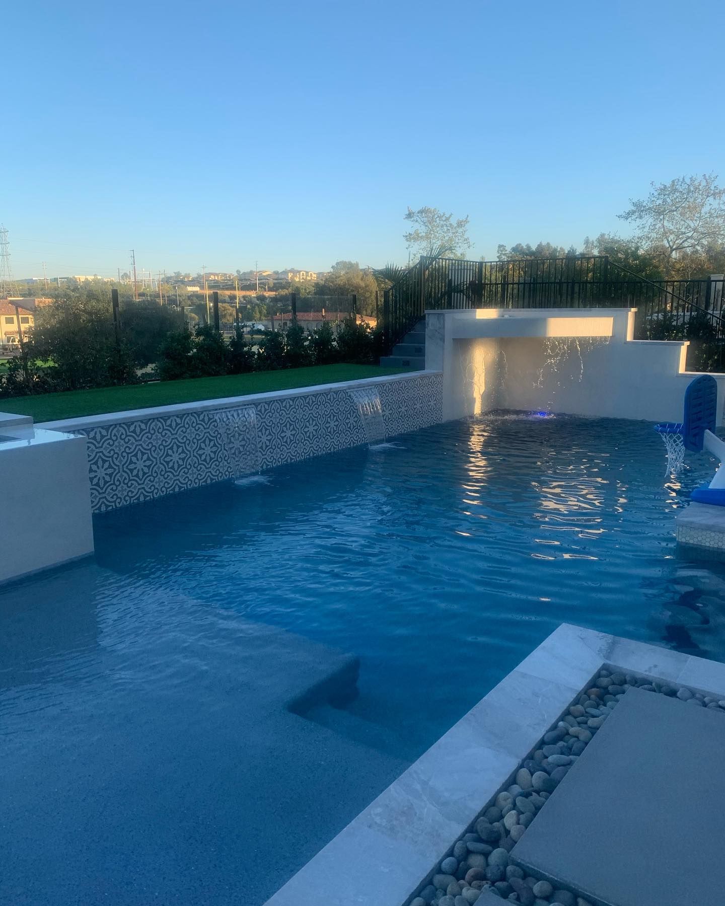 A large swimming pool with a waterfall in the background