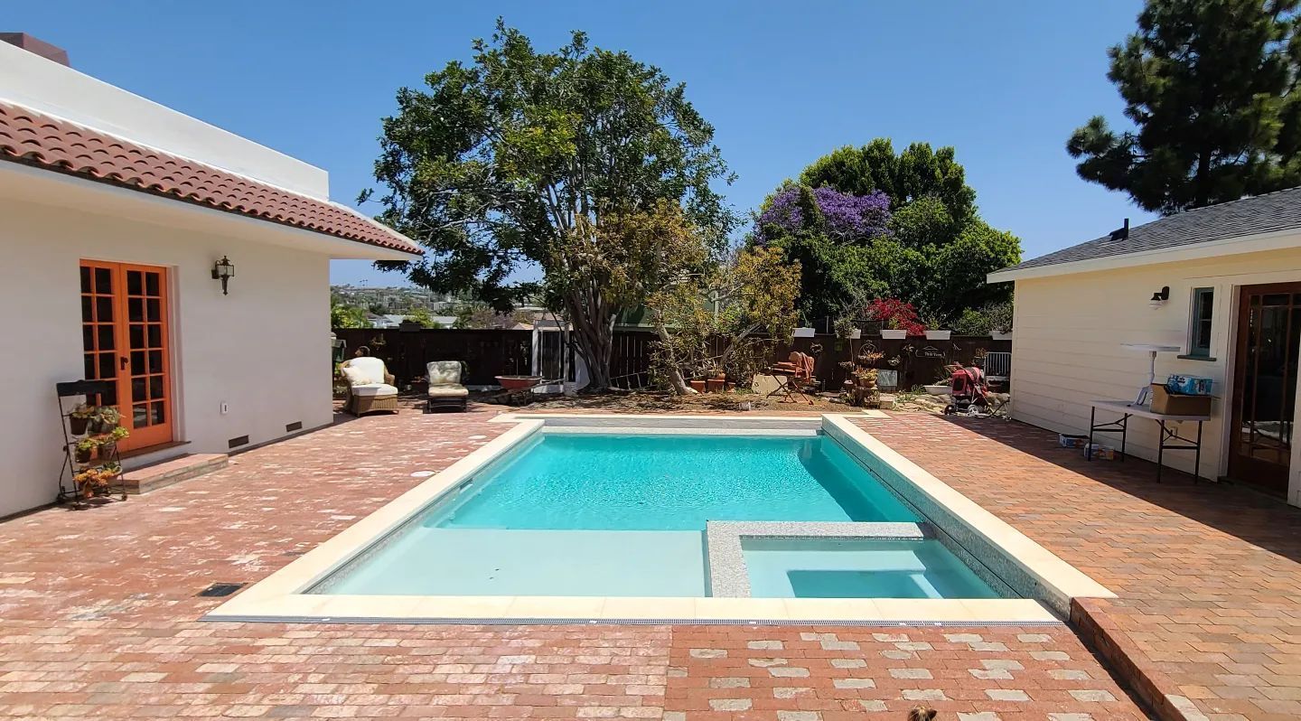 A large swimming pool in the backyard of a house