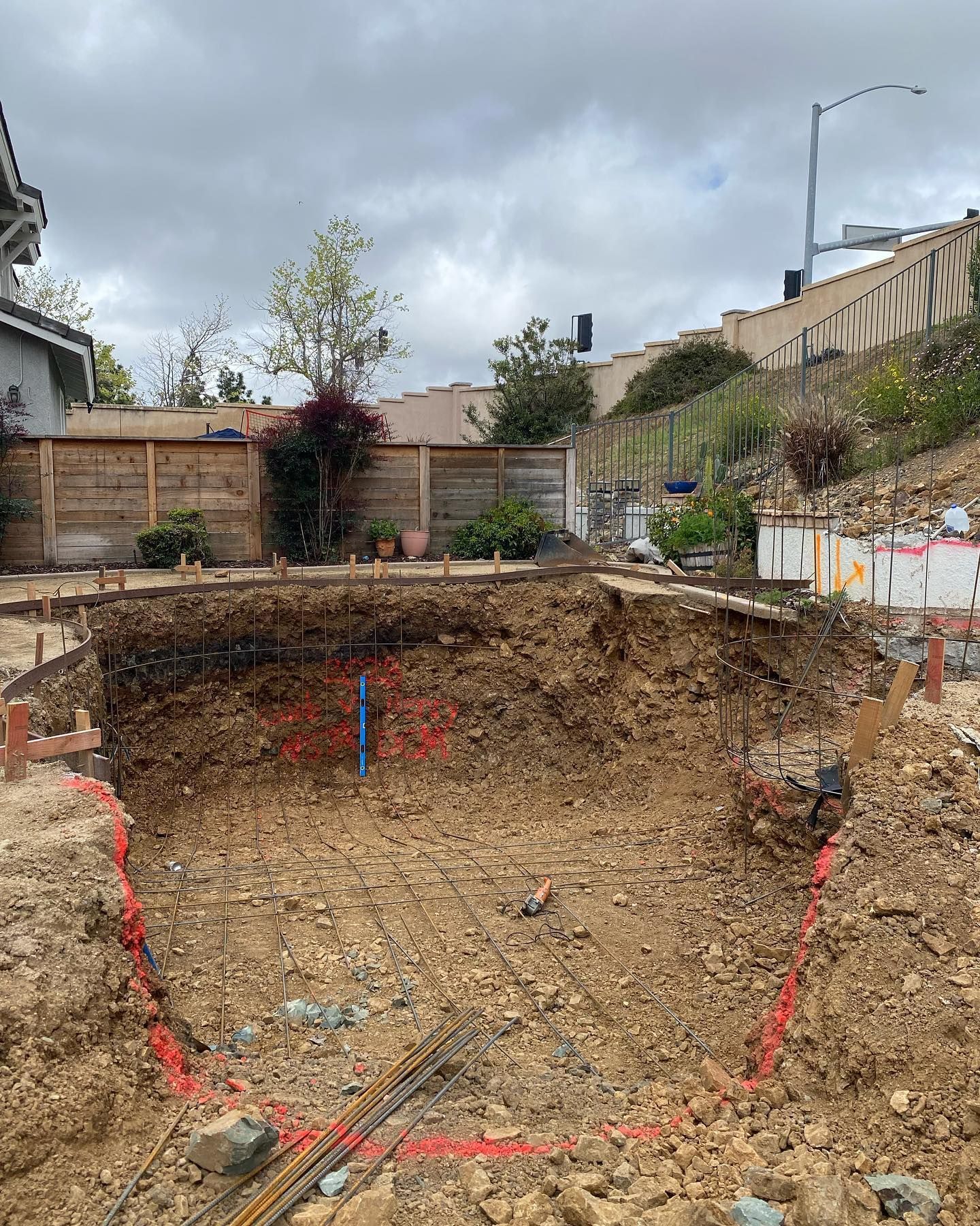 A large hole in the ground is being filled with dirt.