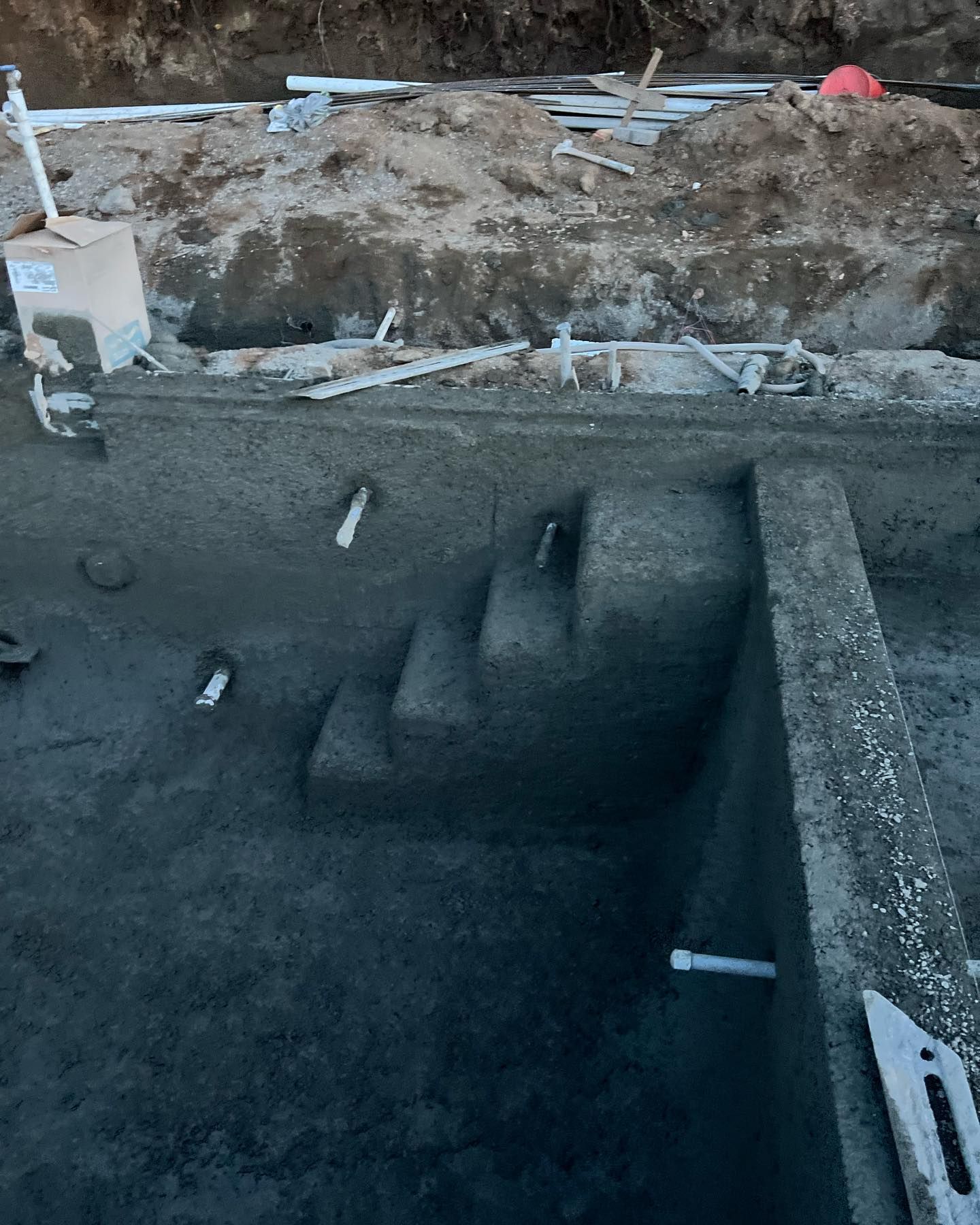 A swimming pool is being built in a hole in the ground.