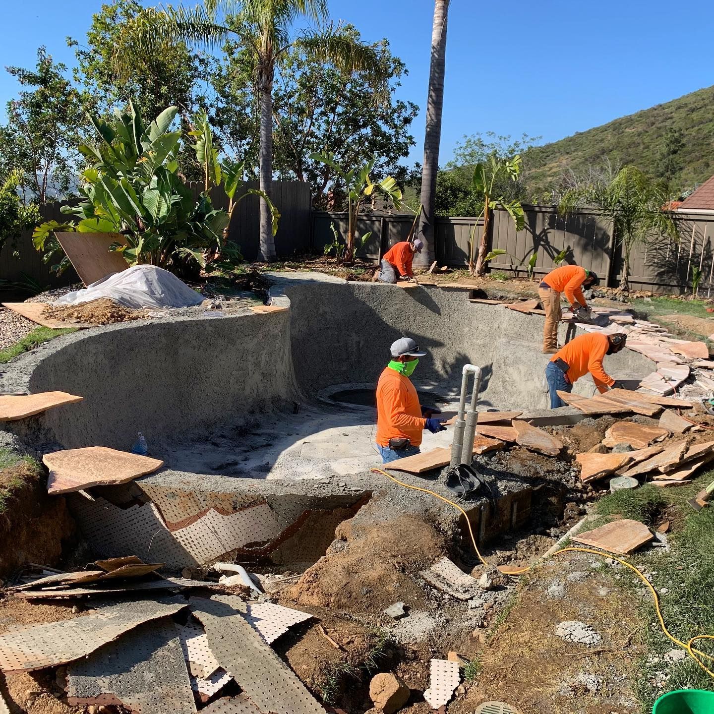 A group of construction workers are working on a pool.