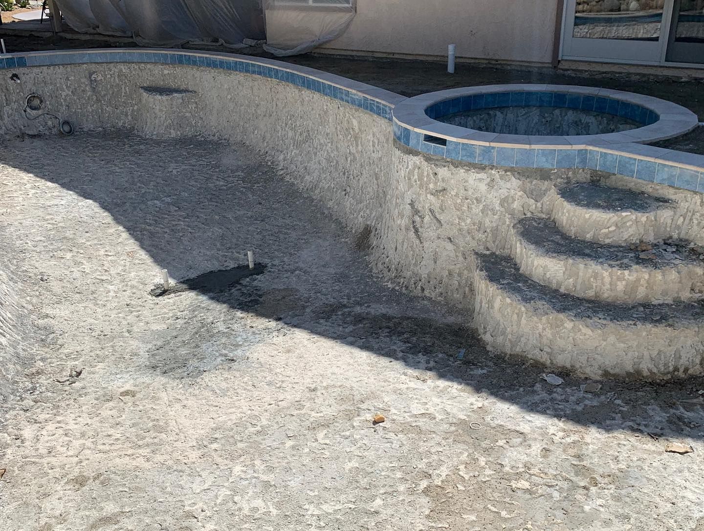 An empty swimming pool with stairs leading up to it.