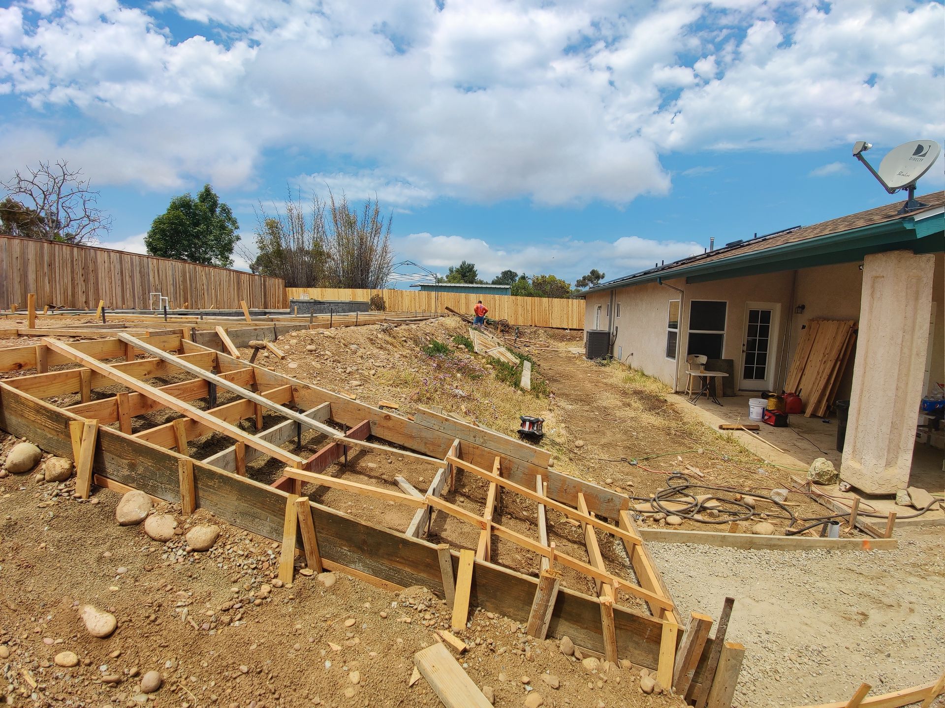 A house is being built on top of a dirt hill.