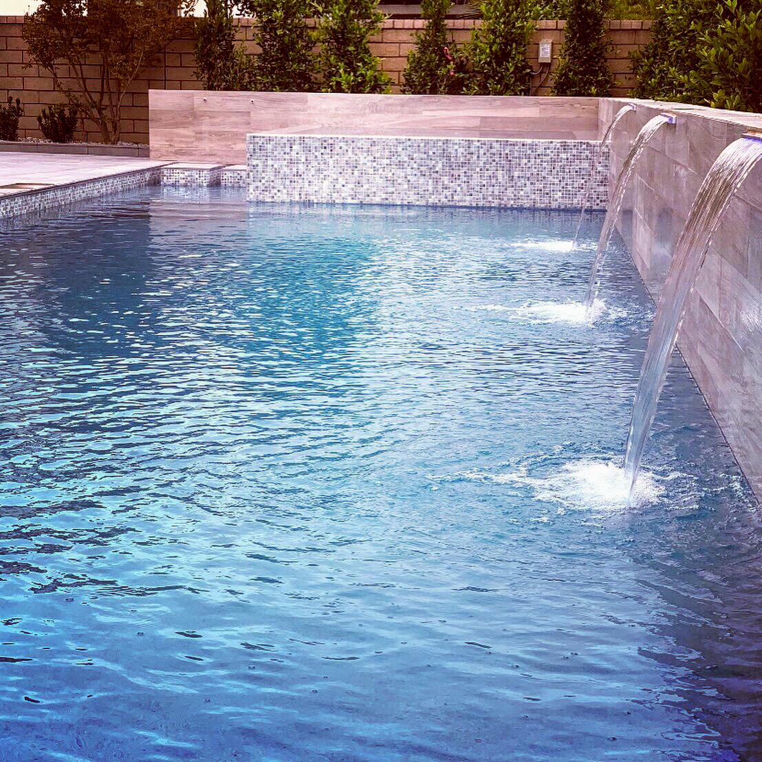 There is a waterfall in the middle of the pool.