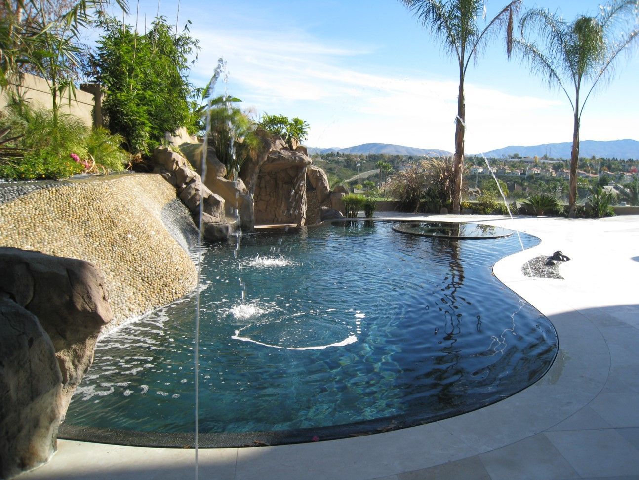 A large swimming pool with a waterfall in the background