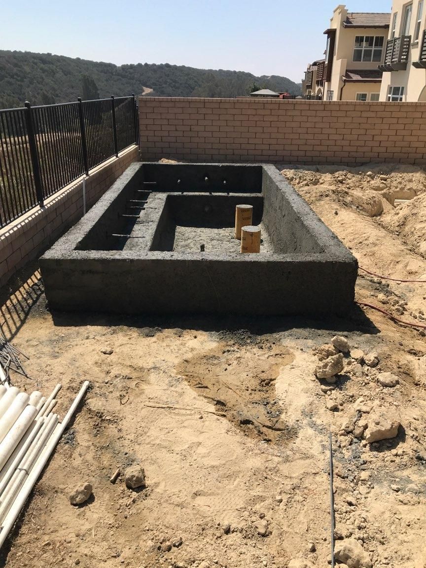 A large concrete block is sitting in the middle of a dirt field.