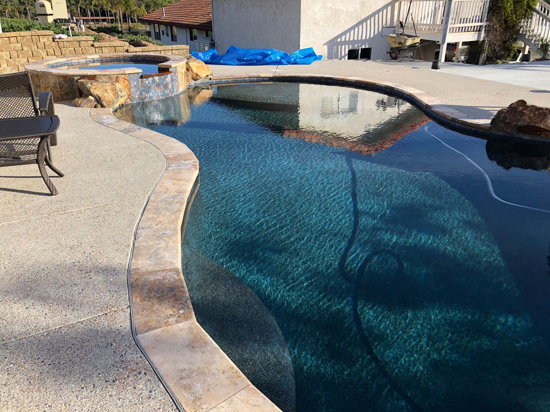 A large swimming pool with a chair in the foreground