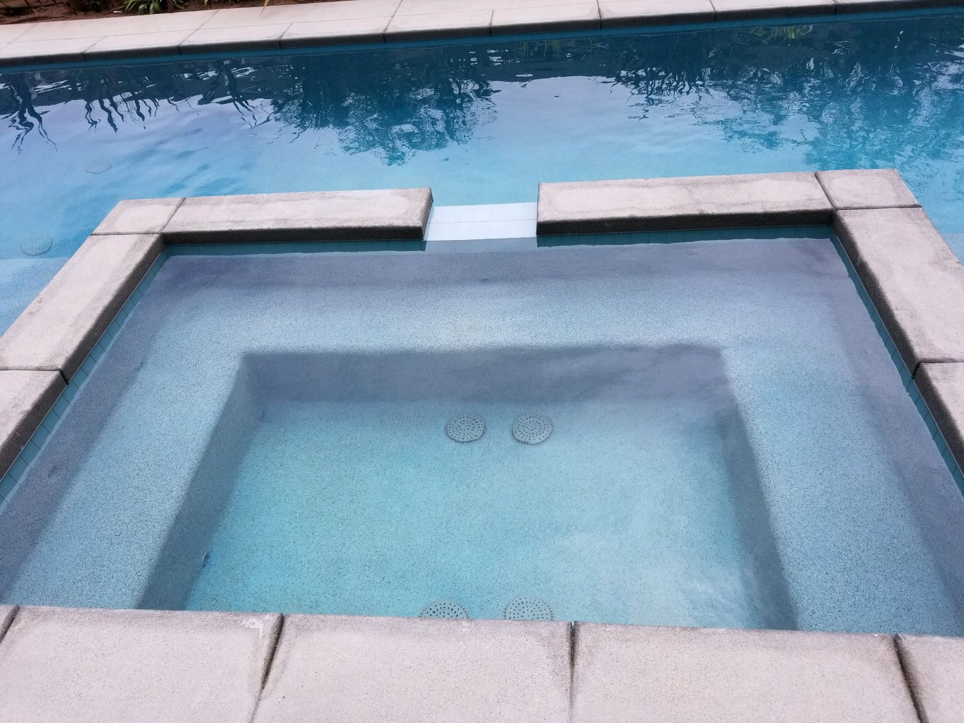 A hot tub in the middle of a swimming pool