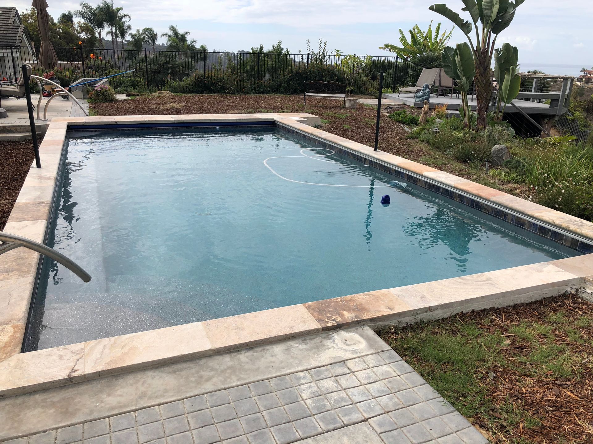 A large swimming pool with a basketball hoop in the middle of it