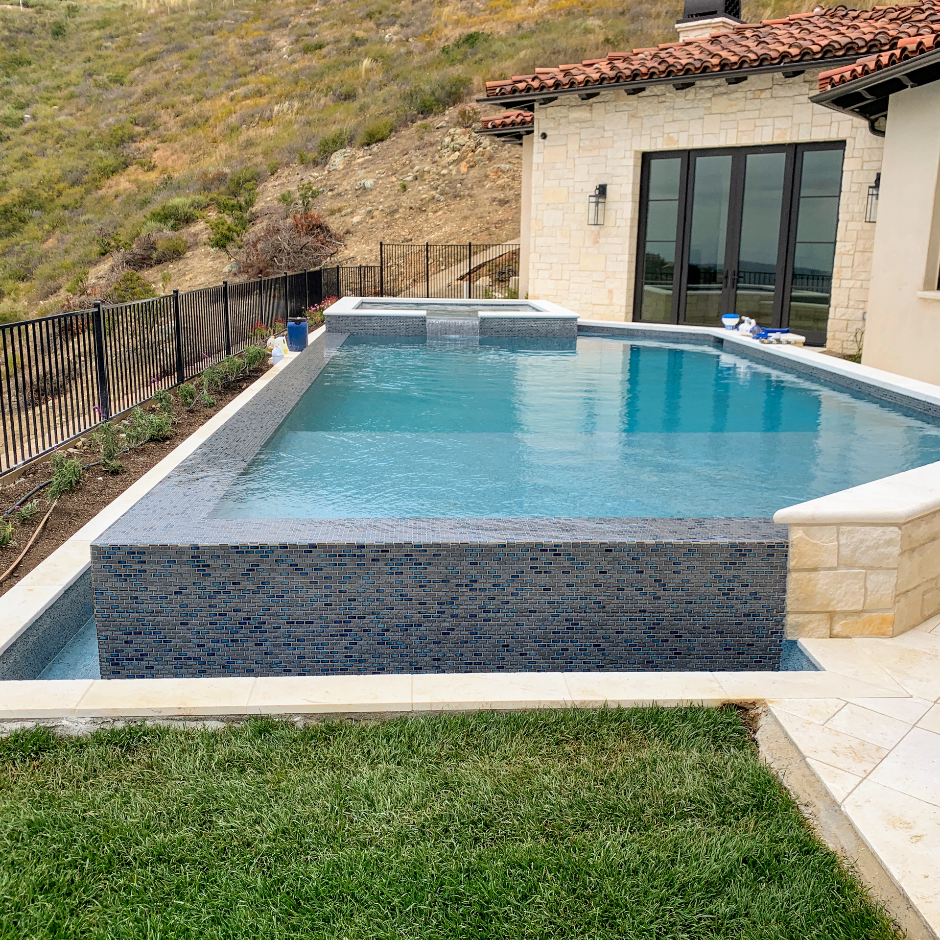 A large swimming pool with a house in the background
