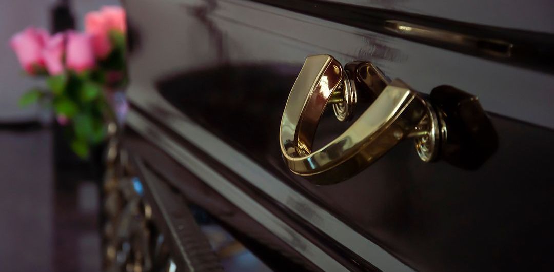 a close up of a gold handle on a piano with roses in the background .